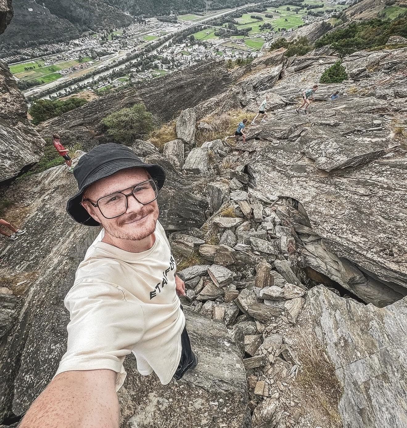 Pierre Biege macht ein Selfie mit einer Gruppe im Felsgelände
